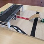 Maquette van De Koepel, een glazen station met bezoekerscentrum en groene dijk.